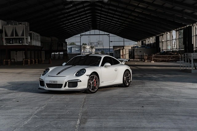 Autogutachter bewertet Porsche 911 – Schadensaufnahme in Weiß Weißer Porsche 911 wird von einem Autogutachter bewertet