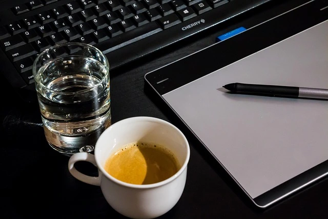 Autokaufvertrag Muster geöffnet auf dem Bildschirm, daneben Tastatur, Kaffeetasse und Tablett auf einem Schreibtisch