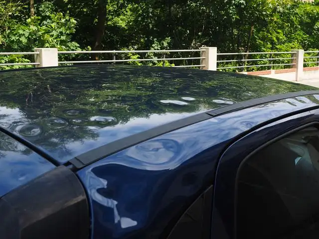 Ein Auto mit sichtbaren Dellen auf der Karosserie, die durch einen Hagelschaden verursacht wurden