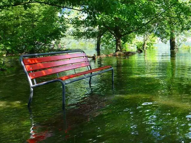Ein Auto mit sichtbaren Hochwasserschäden, das nach einer Überschwemmung auf einem Parkplatz steht
