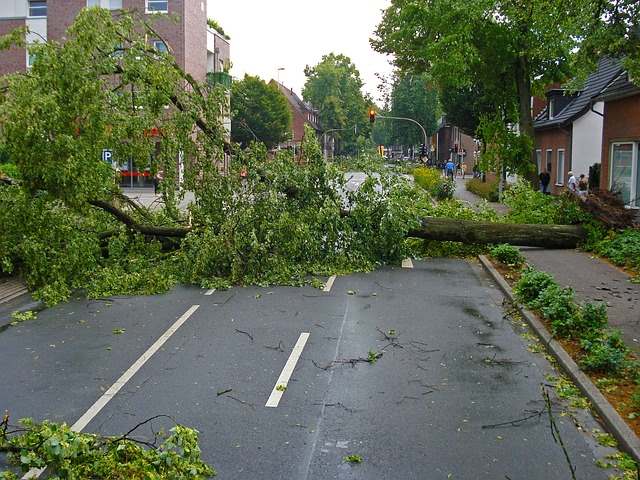 Ein Auto mit Hagelschäden an der Karosserie, das nach einem starken Unwetter auf einem Parkplatz abgestellt ist